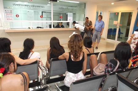 Several Beach Road loiterers await their turn to pay their 100 baht fines at Pattaya police station.